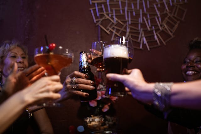 a group of people cheersing with varied alcoholic beverages